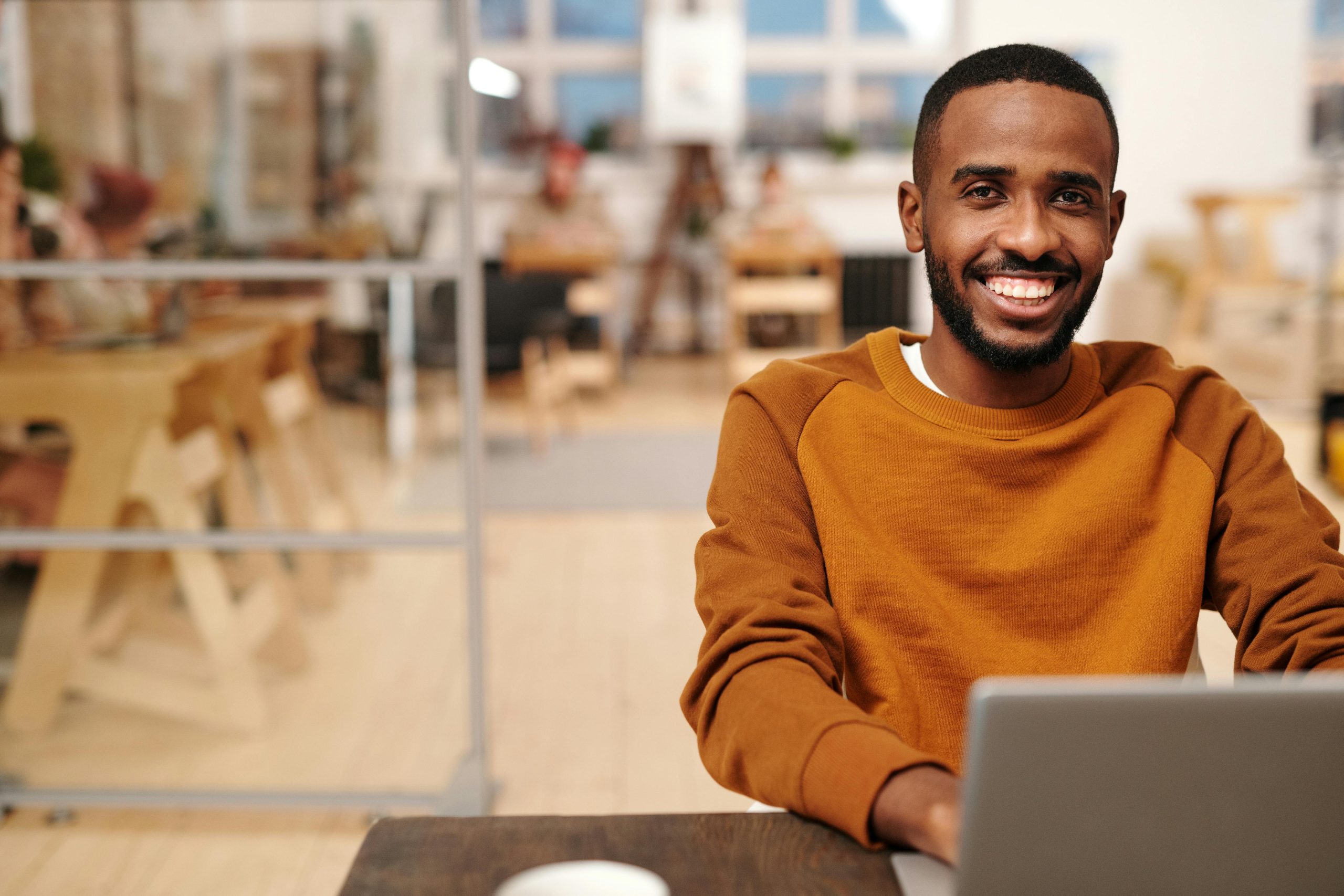 Friendly smiling man at computer in office