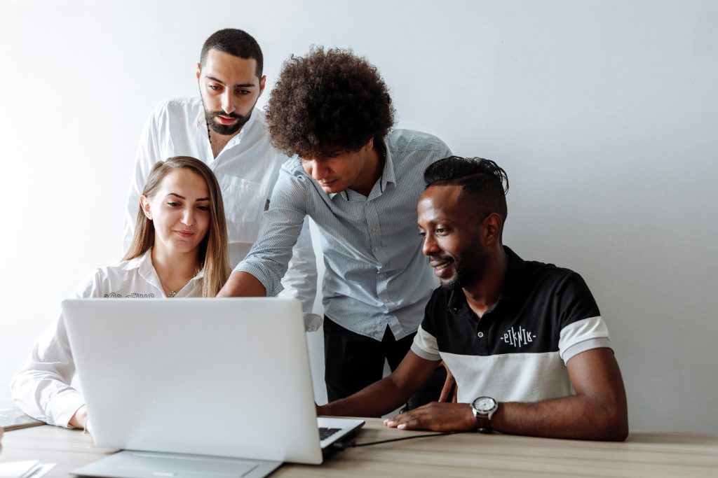 young people looking at laptop screen at a table