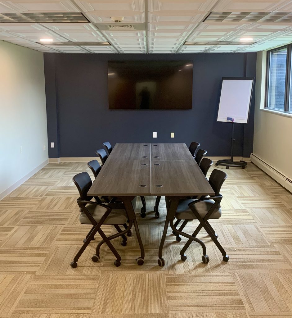 conference room with a long table, easel and monitor